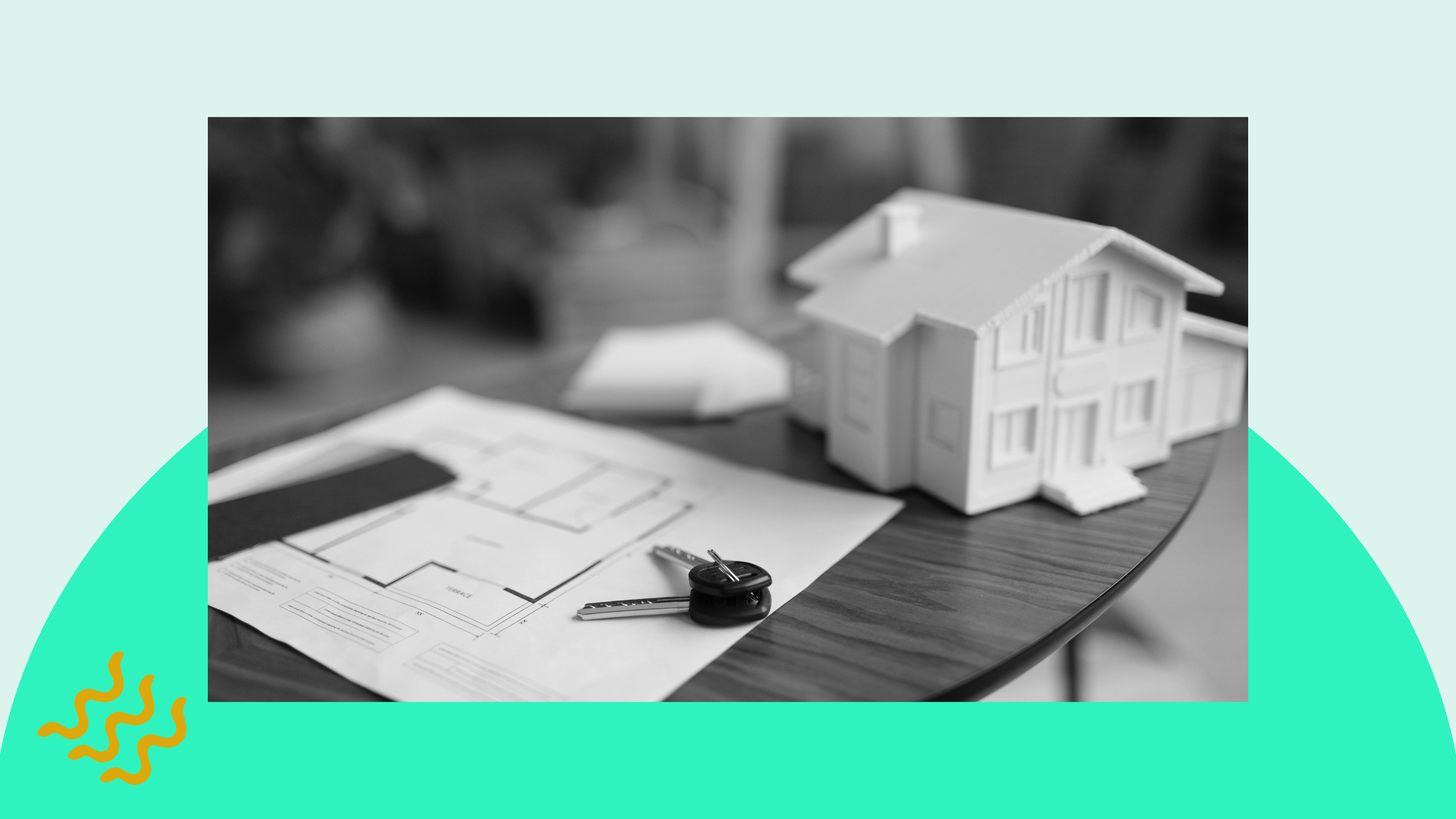 A house and keys sit atop building blueprints on a property manager's desk